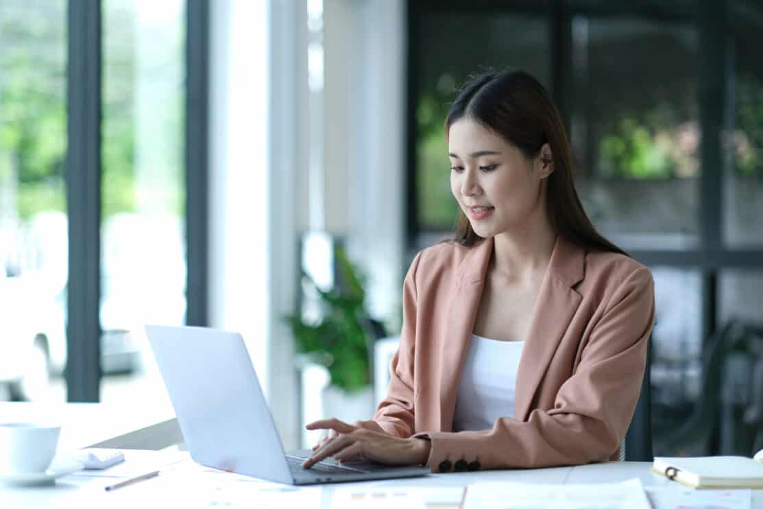charming-asian-businesswoman-sitting-working-on-laptop-in-office
