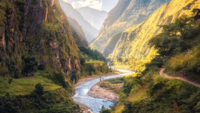 colorful-landscape-with-high-himalayan-mountains-beautiful-curving-river-green-forest-blue-sky-with-clouds-and-yellow-sunlight-at-sunset-in-summer-in-nepal-mountain-valley-travel-in-himalayas