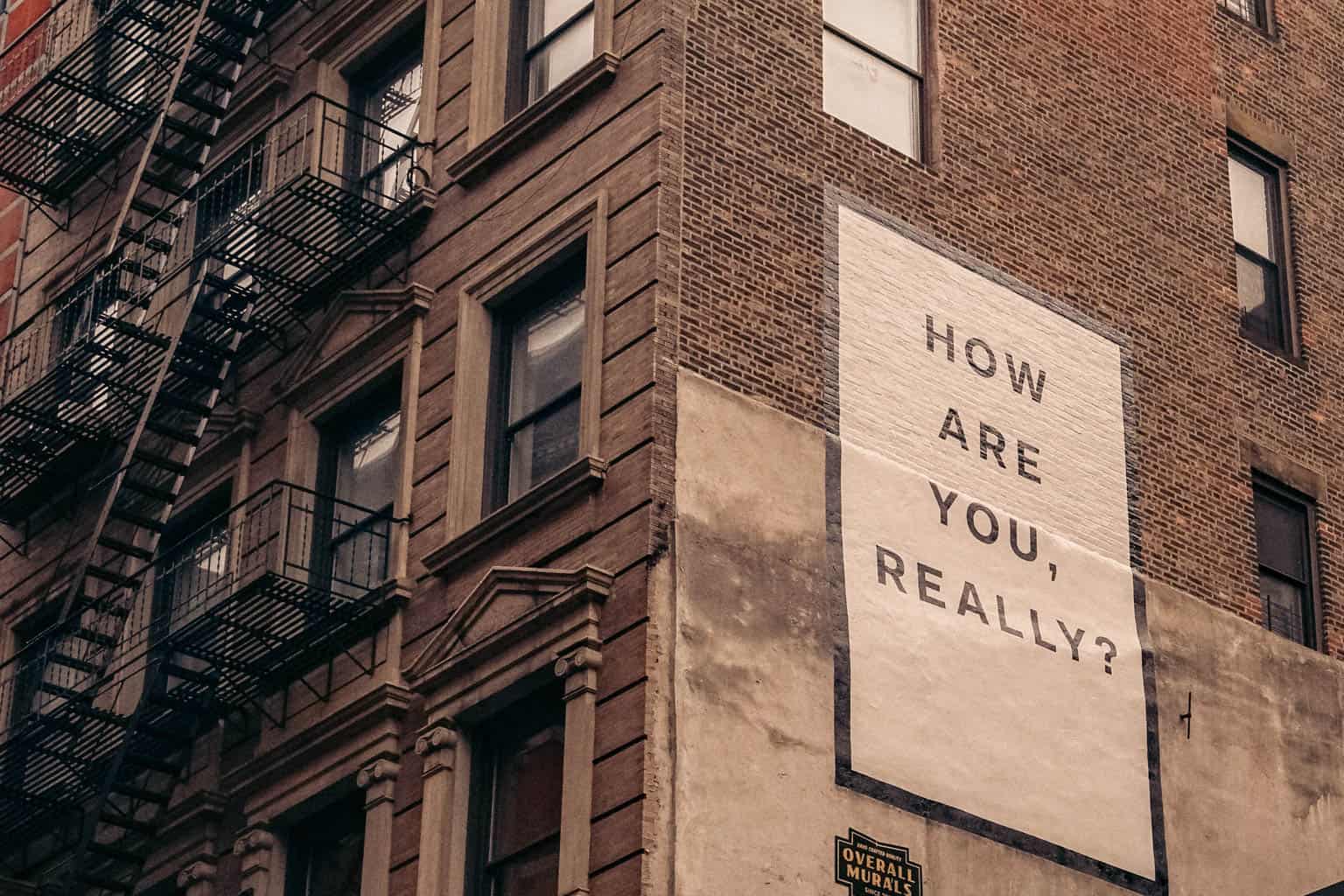 "How Are You Really" poster on a building.