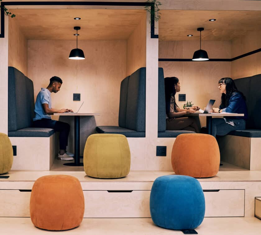 People working in their own workspaces with colorful chairs.
