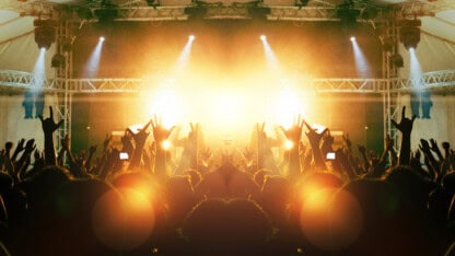 Music artist playing a live concert during a tour in front of an enthusiastic crowd