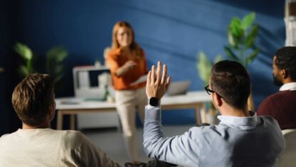Instructor calling on a student with an arm raised.