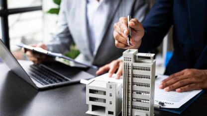 Two professionals in an office setting discussing real estate options and opportunities