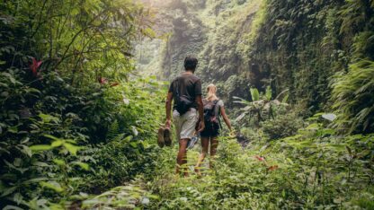 Young couple walking through the woods representing 401(k)s venturing into new terrain