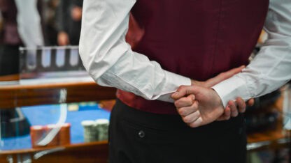 Casino dealer standing by game table with chips in view