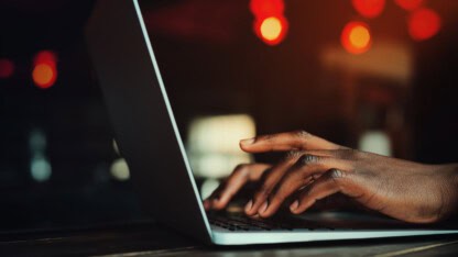 Hands typing on a keyboard representing cyber risks for high-profile individuals