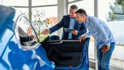 image of men looking into car
