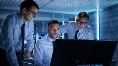 Cybersecurity team gathered around a computer