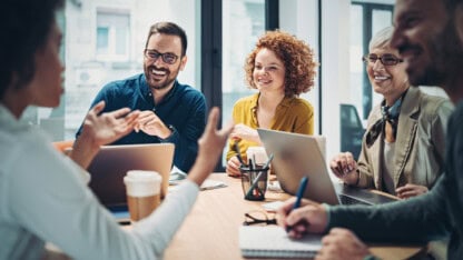Professional services team sitting around a conference table discussing strategic priorities