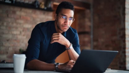 Shareholder researching on computer to determine if stock meets the definition of qualified small business stock (QSBS)