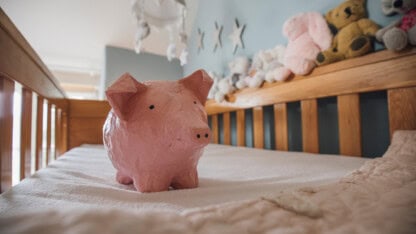 Piggy bank sitting in a crib representing new investment accounts established by the federal government for children