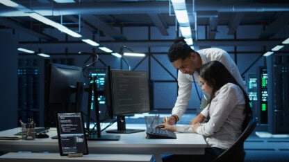 Teamworking colleagues in high tech data center managing and maintaining databases