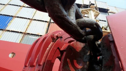 Chain attached to a large shipping vessel representing international commerce