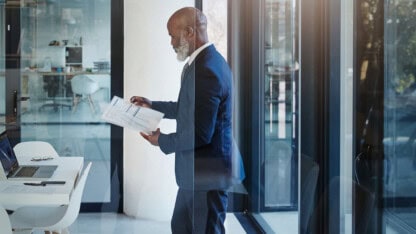 Business man, business and review paperwork at office for financial analysis, corporate report or reading budget info.