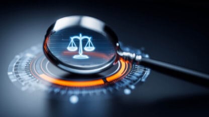 Magnifying glass over the scales of justice.