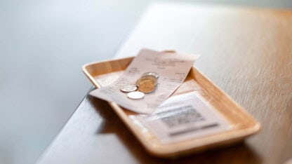 Change tray with a receipt and coins in it.