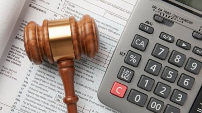 Gavel and calculator over reporting documents representing new IRS Section 987 regulations