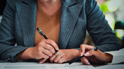 The hands to two professionals reviewing federal grant information for a Single Audit