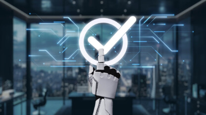 Robotic hand touching a glowing check mark surrounded by blue circuit lines in a futuristic office setting.